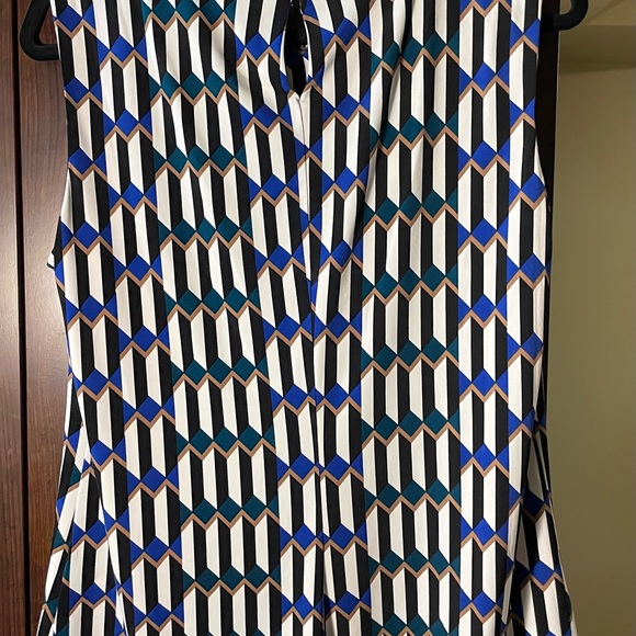 Sleeveless blouse with open pleats at neck and a small button on the back. - Picture 6 of 6